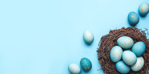 Easter eggs in nest on blue background. Flat lay, top view.