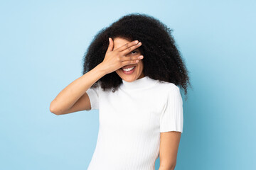 Young african american woman over isolated background covering eyes by hands and smiling