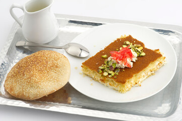 Turkish dessert kunefe, kunafa, kadayif with pistachio powder and cheese, served hot, very sweet. Turkish traditional dessert.Lebanese dessert of Kunafa isolated on white.