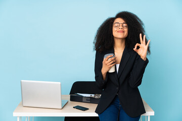 African american business woman working in her workplace in zen pose