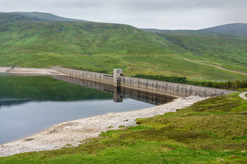 The dam wall of Loch Daimh reservoir water supply in the Scottish Highlands, UK landscapes.