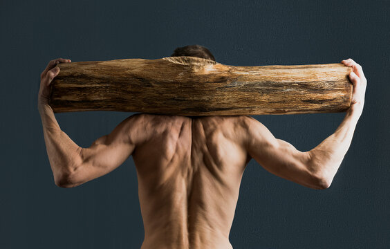 An adult man trains with a log on his neck
