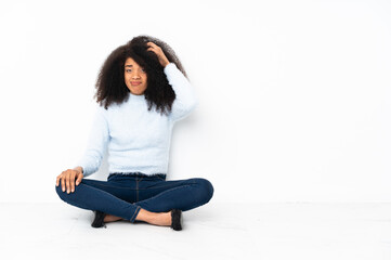 Young african american woman sitting on the floor with an expression of frustration and not understanding