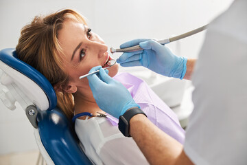 Dental handpiece and mirror during female teeth examining