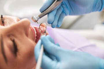 Naklejka premium Medical specialist zooming on teeth with mouth mirror