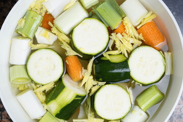 Toma en primer plano de un cuenco con los ingredientes vegetales picados para la elaboración de una crema de verduras.