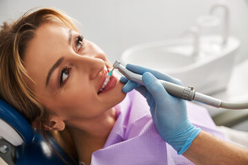 Pretty woman under a tooth polishing procedure