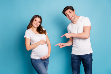 Photo portrait of two people husband pointing finger pregnant wife tummy happy cheerful isolated on vibrant blue color background