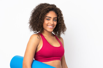 Young African American sport woman isolated on white background with a mat and smiling