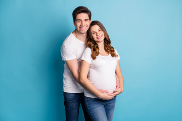 Photo of young lovely happy positive good mood couple family husband hug pregnant wife isolated on blue color background