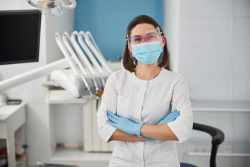 Fototapeta na wymiar Experienced woman dentist standing in the middle of her office