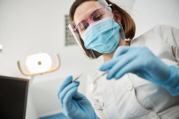 Dental clinic employee staring at tool in her arms