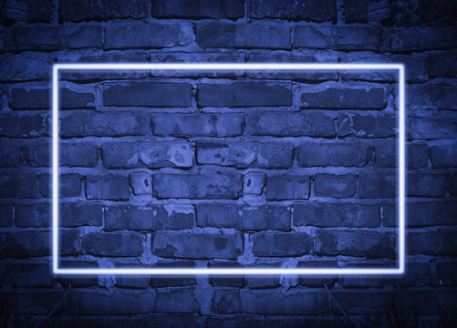 rectangular glowing blue neon frame on brick wall background, place for inscription
