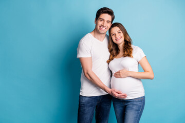 Photo of positive good mood cheerful family waiting baby hugging hand arm tummy isolated blue color background