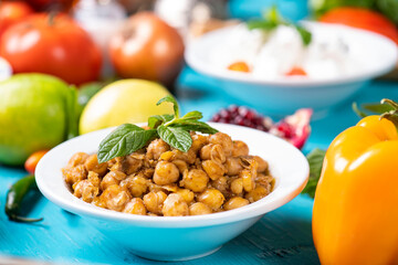 Cooked Chickpeas on bowl on wooden table. Healthy vegetarian plate of cooked chickpeas.