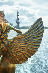 Antique golden statue angel figurehead decorative rostrum ship against the background of the Russian flag