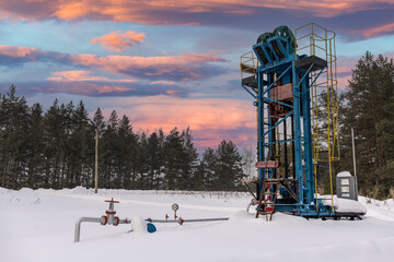 Oil pumpjack winter working. Oil rig energy industrial machine for petroleum in the sunset background for design. Oil pressure gauge shows 9 kgf/cm2 (Max 26 kgf/cm2 - red line)