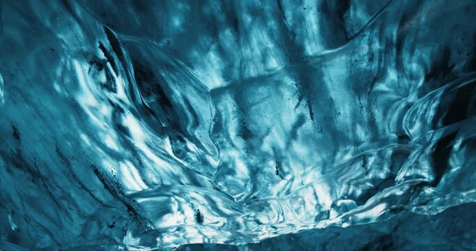 Deeply blue ice forming glacial ice cave slowly melting down in Iceland in winter 4K