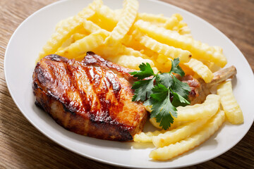 plate of grilled pork with french fries