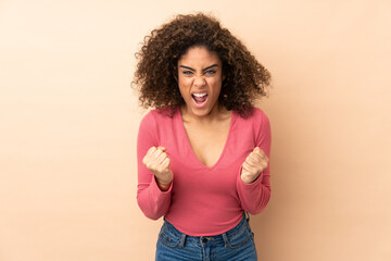 Young African American woman isolated on beige background frustrated by a bad situation