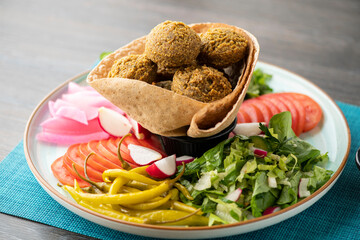 Vegetarian dish - falafel balls from spiced chickpeas with veggies and tartar sauce.