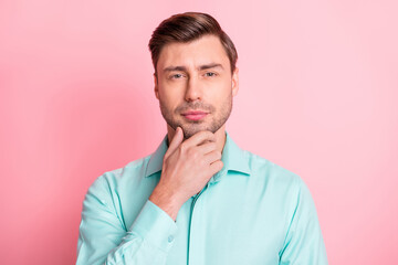 Photo portrait of serious smart businessman touching chin thoughtful isolated on pastel pink color background