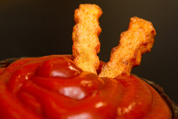 French fries with ketchup. Fries in ketchup close-up. Fastwood and fast food concept.