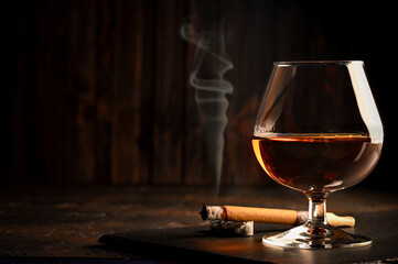 Rum in glasses with a bottle of rum and a cigar in the background.