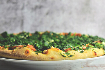 Spinach pizza, with mozzarella and tomato. Close up. Copy space.