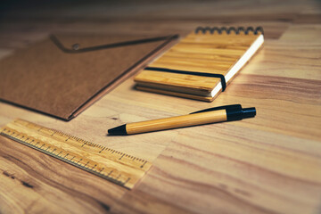 bamboo notebook and wooden pen with sustainable  and eco friendly office supplies on wooden background. the future is to use non-polluting and recyclable materials at work. 