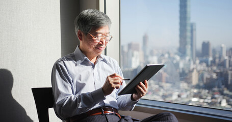 man use tablet near window