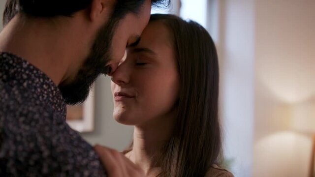 Young couple in love cuddle indoors at home.