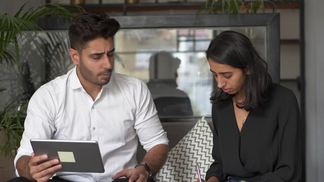 An Angry boss scolding female employee for bad result at workplace,Dissatisfied manager pointing at tablet screen reprimanding incompetent intern for ineffective poor performance or mistakes in work.