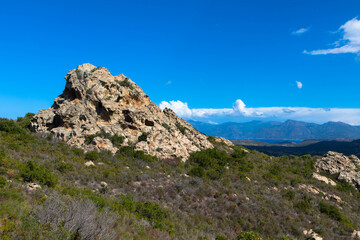 Impressive stone formation in the Mediterranean landscape of the Bavella Mountains with maquis bushes in the foreground.
Corsica, France
