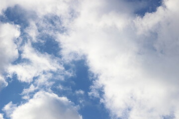 Obraz premium Bright March blue sky with white and gray clouds in sun light