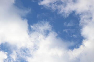 Bright March blue sky with white and gray clouds in sun light