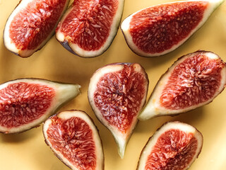Even slices of fresh figs cut on a yellow background.