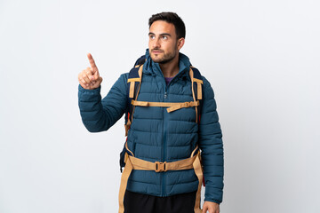 Young mountaineer man with a big backpack isolated on white background touching on transparent screen