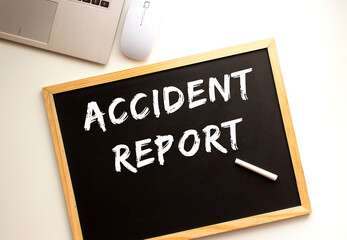 Text ACCIDENT REPORT written in chalk on a slate board. Office desk.