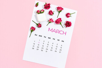 International Womens day, 8 March. Little pink roses on march calendar leaf over pink pastel background