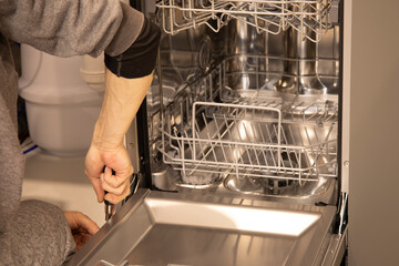 Master installing the dishwasher in a kitchen