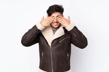 Arabian handsome man over isolated background covering eyes by hands and smiling