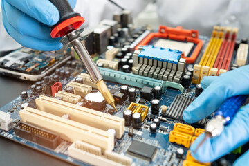 technician repairing inside of hard disk by soldering iron. Integrated Circuit. the concept of...