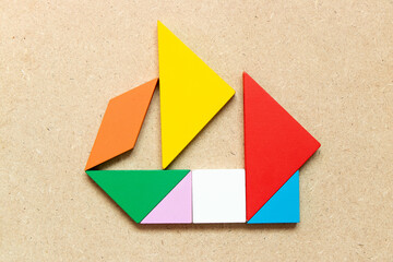 Color tangram in sailing boat shape on wood background (Concept for business start up or entrepreneur)