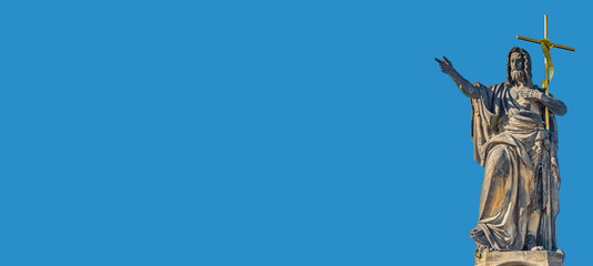 Banner with ancient statue of saint with cross at the Charles Bridge in Prague at blue sky and copy space for text, Prague, Czech Republic.