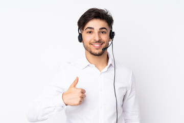 Telemarketer Arabian man working with a headset isolated on white background giving a thumbs up...