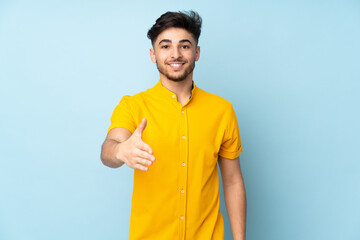 Arabian handsome man over isolated background shaking hands for closing a good deal