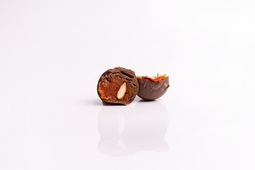 Chocolate candies with apricot filling with almond nut on a white background