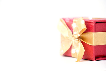 Red gift box and golden ribbon on white and bokeh background, Happy birthday and happy new year concept.