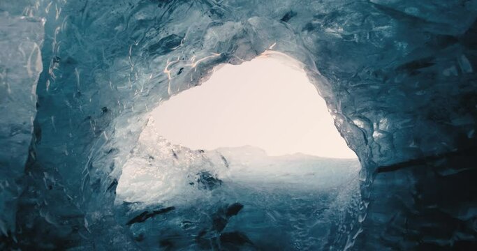 Deeply blue ice forming glacial ice cave slowly melting down in Iceland in winter 4K